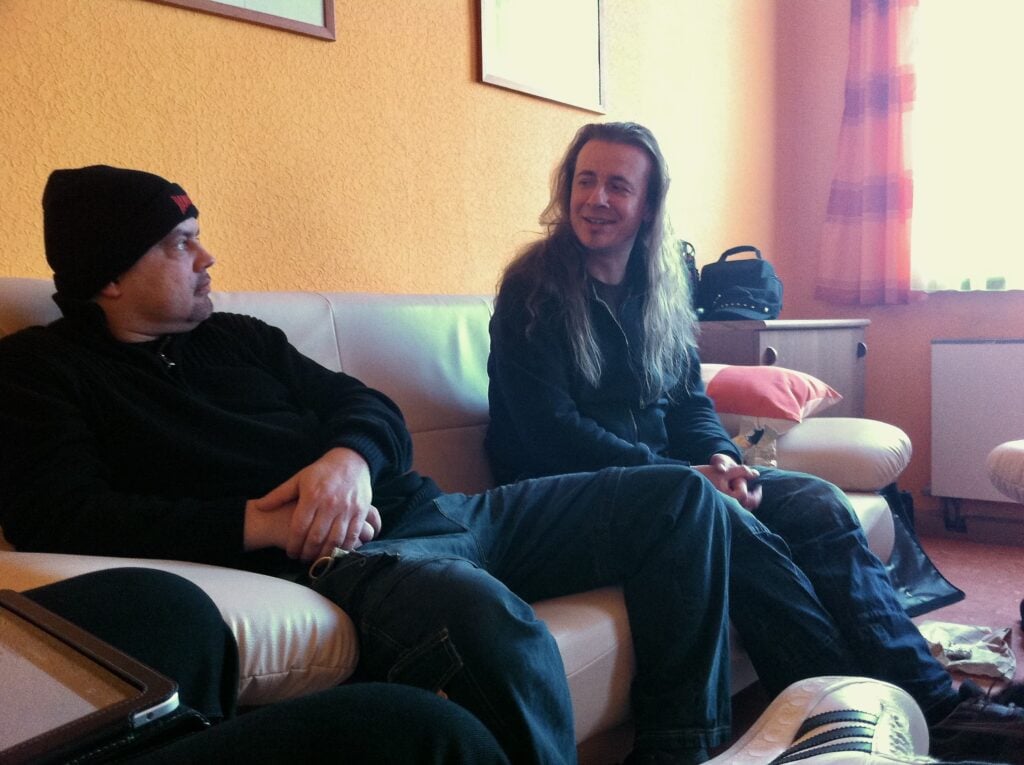 Zwei Männer unterhalten sich auf einem Sofa.